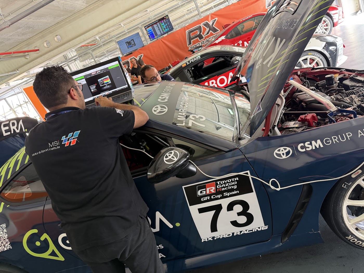 Un ingeniero trabaja en el coche 73 con la marca CSM